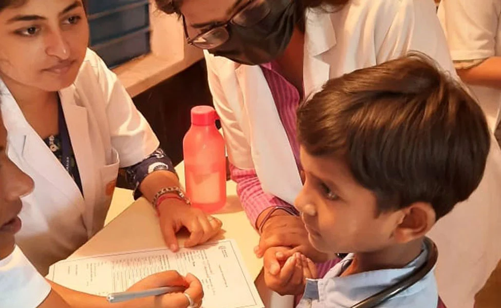 RINER Staff checking health of a child